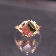 This exquisite vintage ring captures the eye with its striking emerald cut watermelon tourmaline, radiating hues of rich pink and deep green. Weighing just 3 grams, the ring’s petite size and size of 6-1/4 ensure a comfortable fit, while the prong setting showcases the gemstone's vibrant colors to perfection. Crafted out of 14K yellow gold the ring is in excellent condition and ready to become a cherished part of someone’s jewelry collection. Metal: 14K Yellow Gold Gemstone: Watermelon Tourmalin Watermelon Tourmaline Engagement Ring, Watermelon Tourmaline Ring, Tourmaline Engagement Ring, Cut Watermelon, Amber Gemstone, North Myrtle Beach, Myrtle Beach Sc, Ring Pictures, Tourmaline Ring