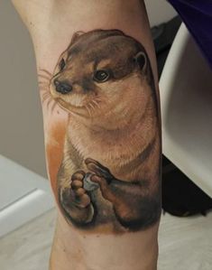 a close up of a person's leg with an animal tattoo on the arm