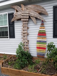 a palm tree made out of wooden pallets in front of a house