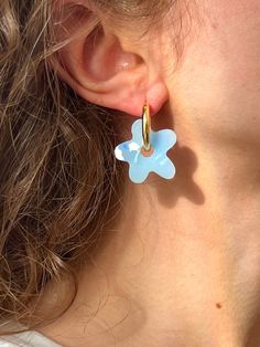 a close up of a person wearing some kind of earring with a flower on it