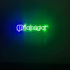 a neon sign that is on the side of a wall in front of a dark background