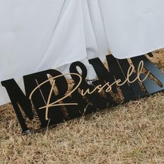 a sign that says dream on it in gold lettering next to a white table cloth