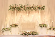 a decorated stage with flowers and candles for a wedding or reception ceremony at the same time