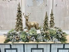 a table topped with plants and deer statues