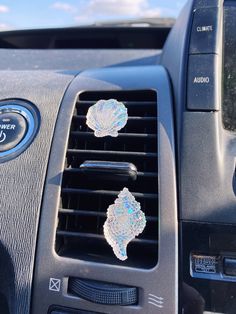 an air vent in the dash of a car with stickers on it's dashboard