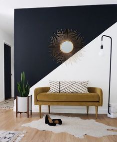 a couch sitting in front of a black and white wall with pink lettering on it