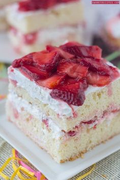 a piece of cake with strawberries on top is sitting on a square white plate