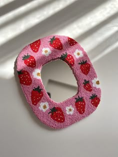 a close up of a small mirror with strawberries on the front and back side