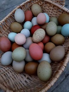 a basket filled with lots of different colored eggs