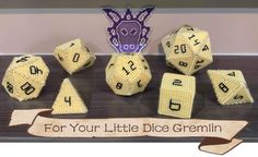 a group of yellow dices sitting on top of a table next to a sign that says for your little dice gremlin