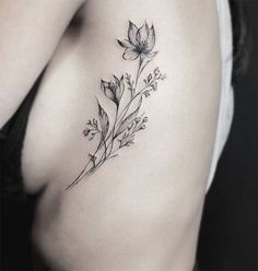 a woman's stomach with a flower tattoo on it