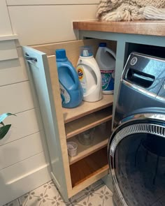 a washer and dryer in a small room with shelves full of cleaning products