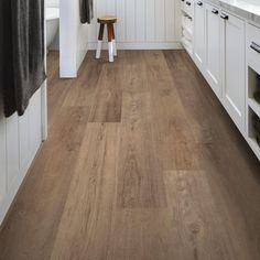 a kitchen with white cabinets and wood flooring