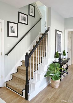 the stairs in this house are painted white and have black railings on each handrail