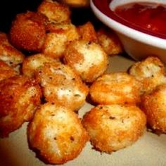 some fried food is next to a bowl of ketchup