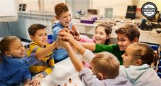 a group of young children holding hands in a room with desks and computer monitors