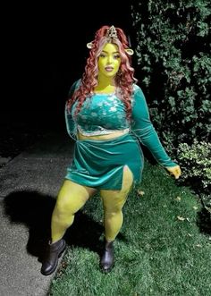 a woman dressed in yellow and green poses for the camera with her hands on her hips