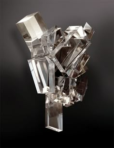 a crystal sculpture sitting on top of a metal table next to a wall mounted light