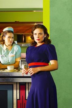 two women are standing in front of a counter