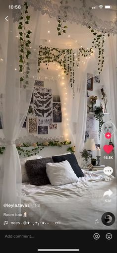 a bed with white curtains and lights hanging from the ceiling