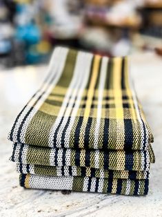 three folded plaid towels sitting on top of a white countertop next to each other