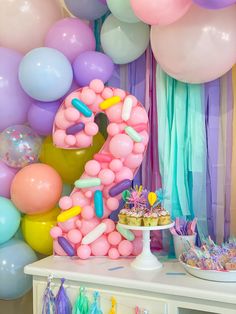 a birthday party with balloons, cake and decorations