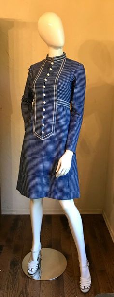 This is a Darling vintage 1970'S dress by Narciso Rodrigues.  It is a heavy woven cotton blend fabric in a blue & white check. It has the white ball buttons and white ribbon trim. Note dress is short waisted so keep in mind for measurements.  Great dress for office, church or to run errands about town. It is in good condition.    As with all vintage please go by measurements below comparing to something in your wardrobe with a good fit. Measurements Lying Flat:  Bust 17”, Empire Waist 14”, Hips Blue Knee-length Vintage Dress For Vintage Fashion, Retro Long Sleeve Dresses With Buttons, Blue A-line Mod Dress, Formal Long Sleeve Blue Vintage Dress, Formal Blue Long Sleeve Vintage Dress, 1970s Fitted Dress With Vintage Pattern, Vintage Blue A-line Dress, Retro Long Sleeve Vintage Dress With Buttons, Retro Vintage Long Sleeve Dress With Buttons