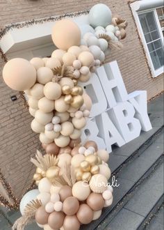 balloons are hanging from the side of a building with gold and white decorations on it