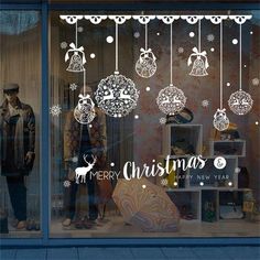 a store front window with christmas decorations and ornaments hanging from it's glass windows