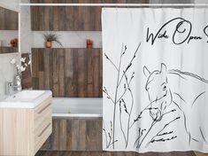 a bathroom with a shower curtain that has an image of a tiger on it and the words wild ones written in black ink