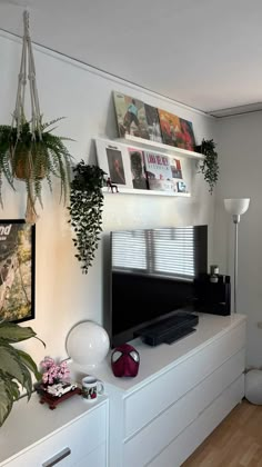 a flat screen tv sitting on top of a white entertainment center in a living room