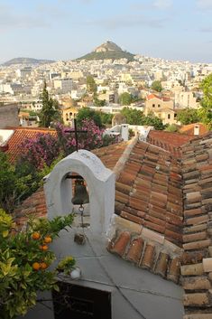 an old roof with a bell tower in the background and some buildings on the other side