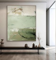 an abstract painting hangs on the wall above a coffee table