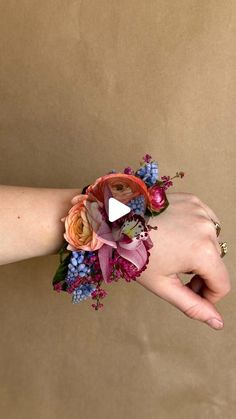 a woman's hand with a wrist corsage made out of fake flowers