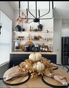 a dining room table with plates and pumpkins on it