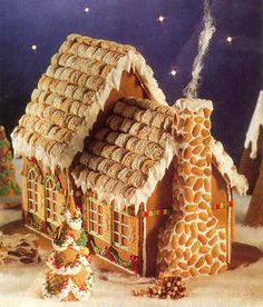 a gingerbread house decorated for christmas in the snow