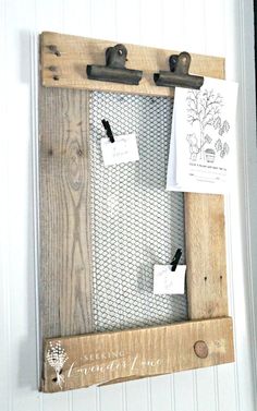 a wooden frame hanging on the side of a wall with clipboards attached to it