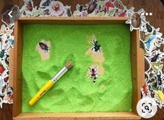 a wooden box with stickers and a paintbrush in it