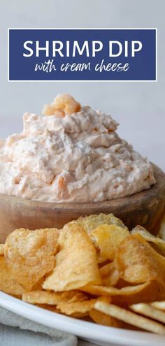 shrimp dip with cream cheese on a white plate next to crackers and chips in a bowl