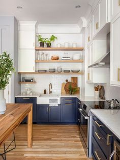 a kitchen with blue cabinets and white walls, wood flooring and open shelving