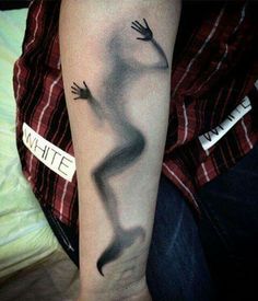 a person with a black and white tattoo on their arm that has an image of a hand coming out of it