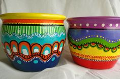 two colorful bowls sitting next to each other on a white surface