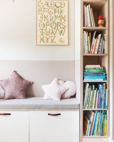 there is a book shelf with books on it and a bench in front of it