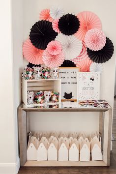 there are many paper fans on the wall above the table and in front of it