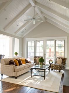 a living room filled with furniture and a ceiling fan