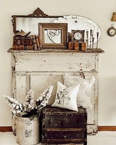 an old trunk with some flowers in it next to a mirror and other items on top