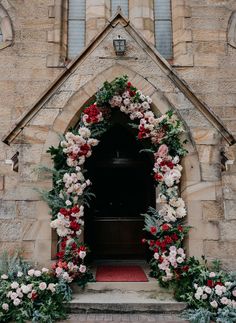 a church door decorated with flowers and greenery