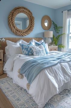 a bedroom with blue walls, white bedding and an oval mirror on the wall