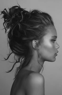 a black and white photo of a woman's face with her hair blowing in the wind