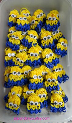 some yellow and blue cupcakes are in a plastic container with googly eyes